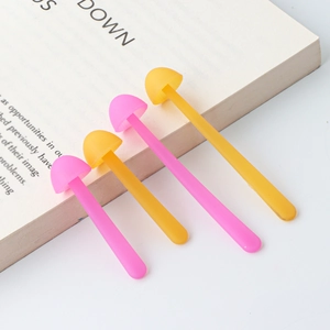 Detail of colorful silicone mushroom bookmarks in pink and yellow on an open book