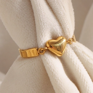 Dettaglio di un anello a cuore placcato oro 18 carati su morbido tessuto bianco