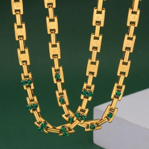 Macro shot of 18K gold plated rectangular links and green crystals on the necklace