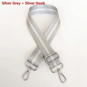 Detail of silver gray nylon bag strap with polished silver metal hooks and adjuster