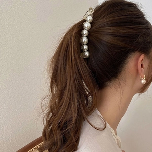 Elegante fermaglio per capelli con perle grandi e orecchini abbinati su modella