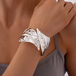 Detailed view of silver leaf-shaped open cuff bracelet with metallic ripple texture