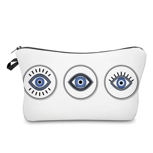 White travel cosmetic bag featuring blue evil eye prints and a black wrist strap