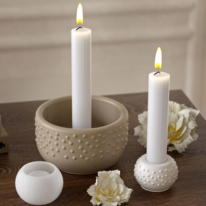 Detailed view of polka dot resin candle holder set with burning candle in cozy home setting