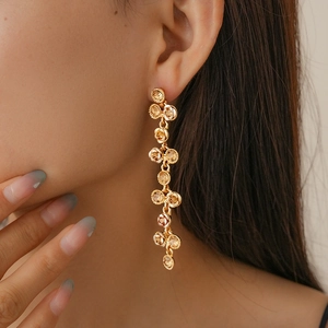 Gros plan de boucles d'oreilles pendantes dorées avec pierres précieuses champagne