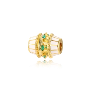 Detail of oval gold bead with green zircon and white enamel for DIY jewelry making