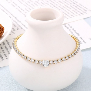 Bracelet tennis en acier doré avec zircon en cœur sur fond décoratif élégant