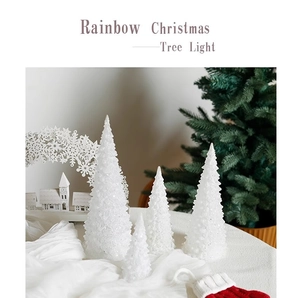 Detail of four acrylic glowing mini Christmas tree lights on a festive tabletop setup