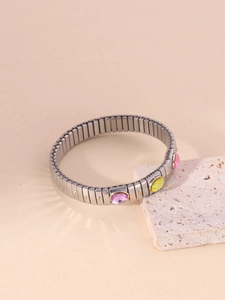 Detail view of gold-plated titanium bracelet with purple, yellow, and pink oval acrylic stones