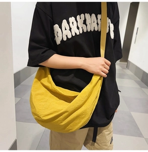 Sac bandoulière en nylon jaune de style décontracté porté par un mannequin