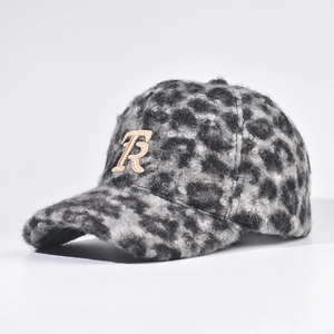 Close-up of thick leopard print lamb wool fabric and golden letter R detail on baseball cap