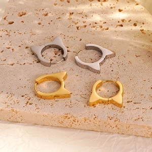 Polished stainless steel cat ear earrings in gold and silver finish on stone background