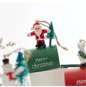 Close-up of red Christmas mailbox ornament with Santa Claus and a mini tree topper
