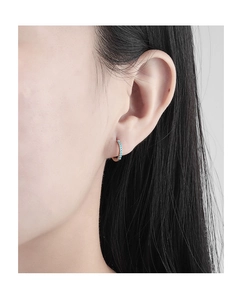 Macro view of gold-plated hoop earrings with inlaid turquoise stones on a female model