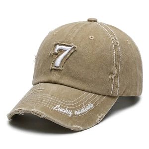 Close-up of khaki distressed baseball cap with 7 embroidery and frayed hole detail