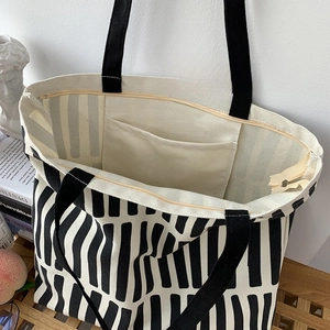 Detail of canvas tote bag showing secure zipper closure and internal open pocket