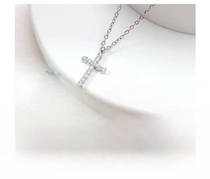 Macro detail of silver cross pendant necklace with micro-pave cubic zirconia crystals