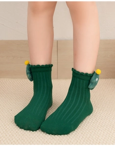 Detail of kids green ribbed Christmas socks with 3D tree decoration on model