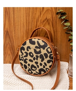 Close-up of leopard print round bag with canvas texture and leather handles
