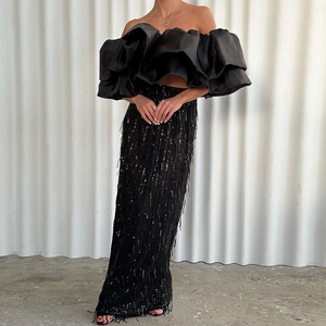 Gonna lunga nera con paillettes e nappe e top a balze con spalle scoperte alla moda
