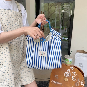 Detailed blue striped canvas tote bag featuring woven circular handles for casual commuting