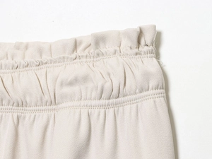 Detailed macro view of beige puff sleeve shirt trousers set elastic waistband and twill fabric