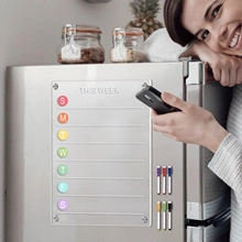 Magnetic acrylic weekly planner on fridge with six colorful markers and round magnets