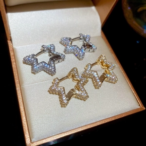 Detail showing star-shaped gold and silver hoop earrings with clear zircon stones