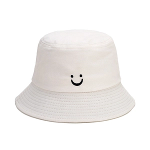 Detail of embroidered smiley face on beige cotton canvas kids bucket hat for sun protection