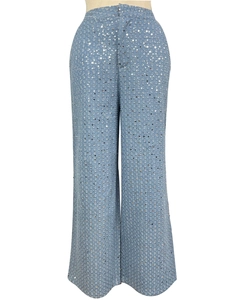 Détail d'un jean large bleu clair orné de paillettes argentées scintillantes sur denim