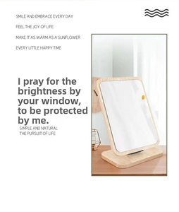 Close-up of square desktop mirror with wooden frame and small yellow flower detail