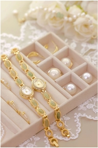 Elegant jewelry box with vintage gold watches and green oval jade stones and earrings