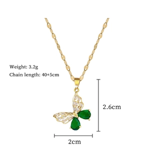 Macro detail of butterfly pendant with emerald zircon and golden titanium steel chain
