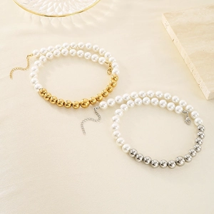 Dettaglio di collane in oro e argento con eleganti perle bianche d'imitazione
