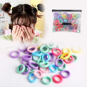 Colorful elastic fabric hair ties set in clear packaging with kids model showing usage