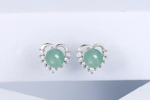 Detail shot of S925 silver heart stud earrings with pale green gemstones and zircons