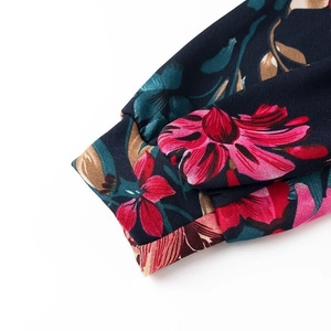 Detail of floral chiffon sleeve cuffs with vibrant pink flowers on dark blue fabric