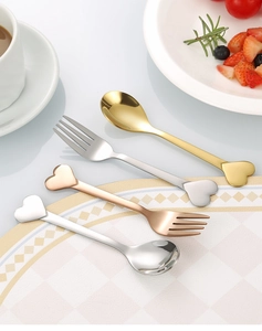 Macro shot of stainless steel heart-shaped spoons and forks set in various metallic finishes