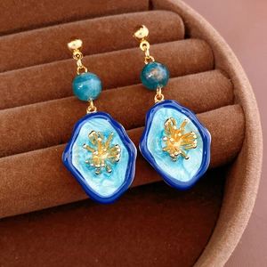 Detailed close-up of vintage oval floral earrings with blue enamel and gold finish details