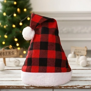 Weihnachtsmütze mit rot-schwarzem Karomuster und weißem Plüschsaum vor einem Festbaum