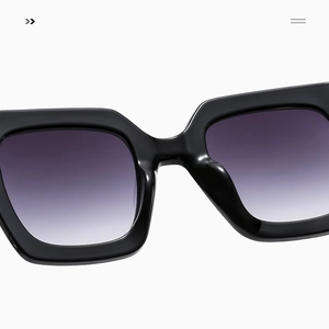 Close-up of black oversized square sunglasses with purple gradient lenses and metal chain temples