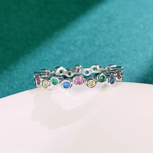 Macro shot of silver eternity ring with colorful round-cut crystals in bezel setting
