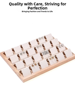 Detail view of 24-slot solid wood jewelry tray with white U-shaped earring inserts