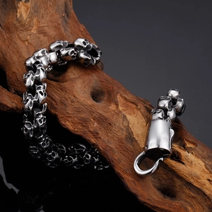 Detailed shot of a punk skull bracelet on a rustic wood branch with stainless steel lobster clasp