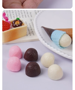 Miniature realistic chocolate balls and dollhouse dessert models on a white decorative plate