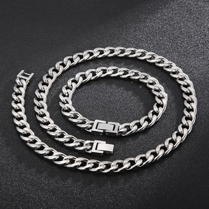 Polished stainless steel Cuban link necklace and bracelet set on black background