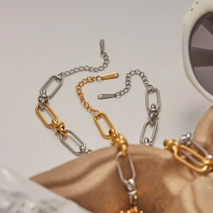 Détail d'une chaîne bicolore or et argent en acier inoxydable avec gravure S-STEEL