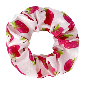 Close-up of white fabric scrunchie with pink strawberry print and glossy finish