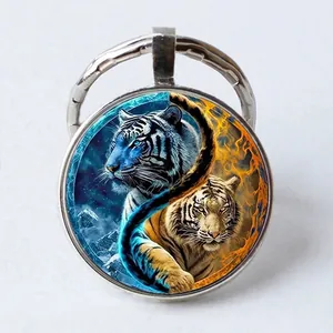 Round metal keychain featuring a blue and orange fire tiger Tai Chi Yin Yang art glass dome