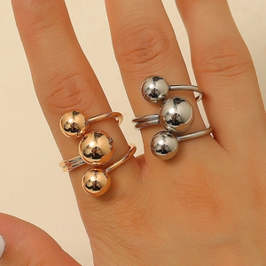 Detail of minimalist stainless steel rings with three vertical beads in gold and silver